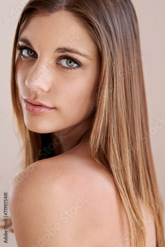 Beauty, cosmetics and portrait of young woman in studio with natural, glow and facial routine. Confidence, makeup and female person with self care, dermatology and face treatment by brown background.
