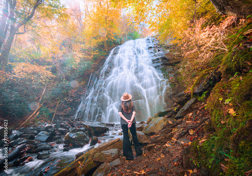 Woman enjoying Crabtree Falls on Blue Ridge Parkway in Fall season.