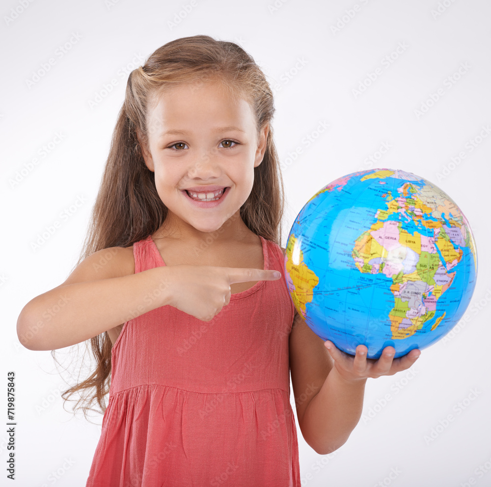 Kid, pointing to globe in studio with world, planets and city for education, geography and portrait. Student, girl child and travel map with smile for earth day support or ecology on white background