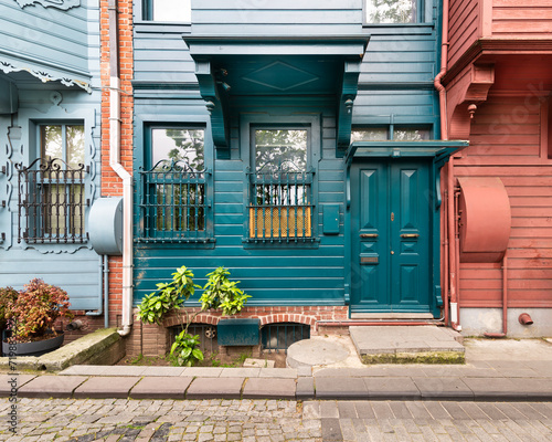 Narrow cobblestone alley with charming green house with wooden decorated door and ornate wrought iron windows, suited in Kuzguncuk neighborhood, Uskudar district, Istanbul, Turkey