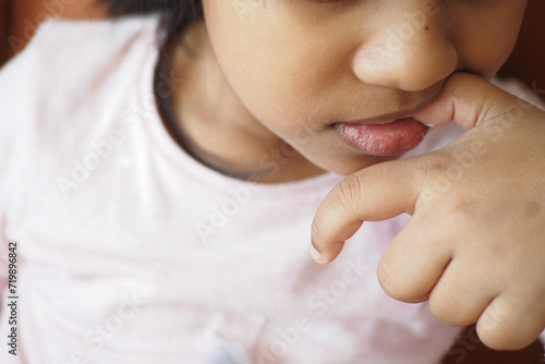  child girl biting her nails at home, photo