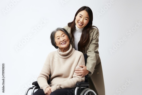 young asian with happy smiling woman in a wheelchair on white background, 