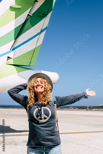 Tourism and tourist travel happy people concept with cheerful and joyful adult beautiful woman ready to leave with the aircraft and fly to detination for holiday vacation photo