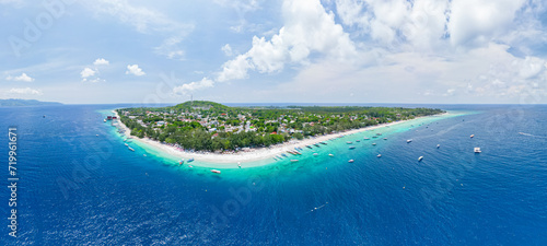 Panoramic Drone photo of Indonesian island, Gili Trawangan and its beautiful crystal clear waters ideal for snorkeling and sailing typical boats. photo