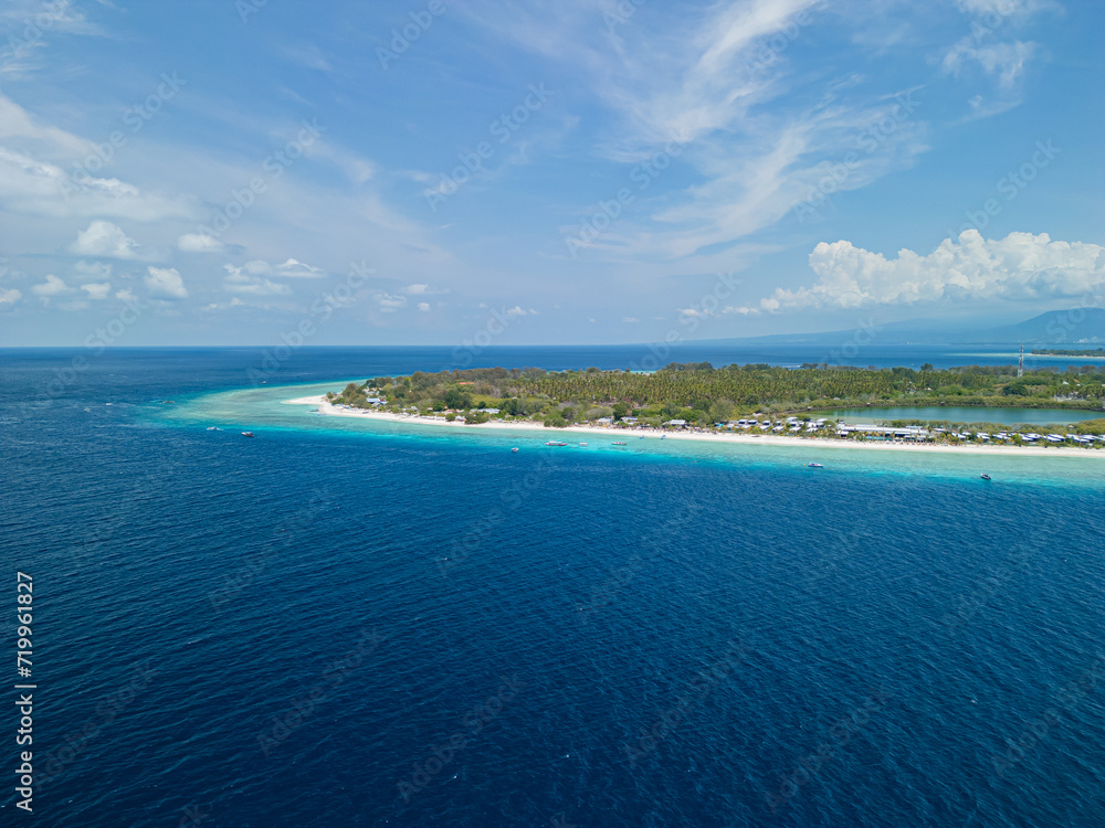 Panoramic Drone photo of Indonesian island, Gili Trawangan and its beautiful crystal clear waters ideal for snorkeling and sailing typical boats.