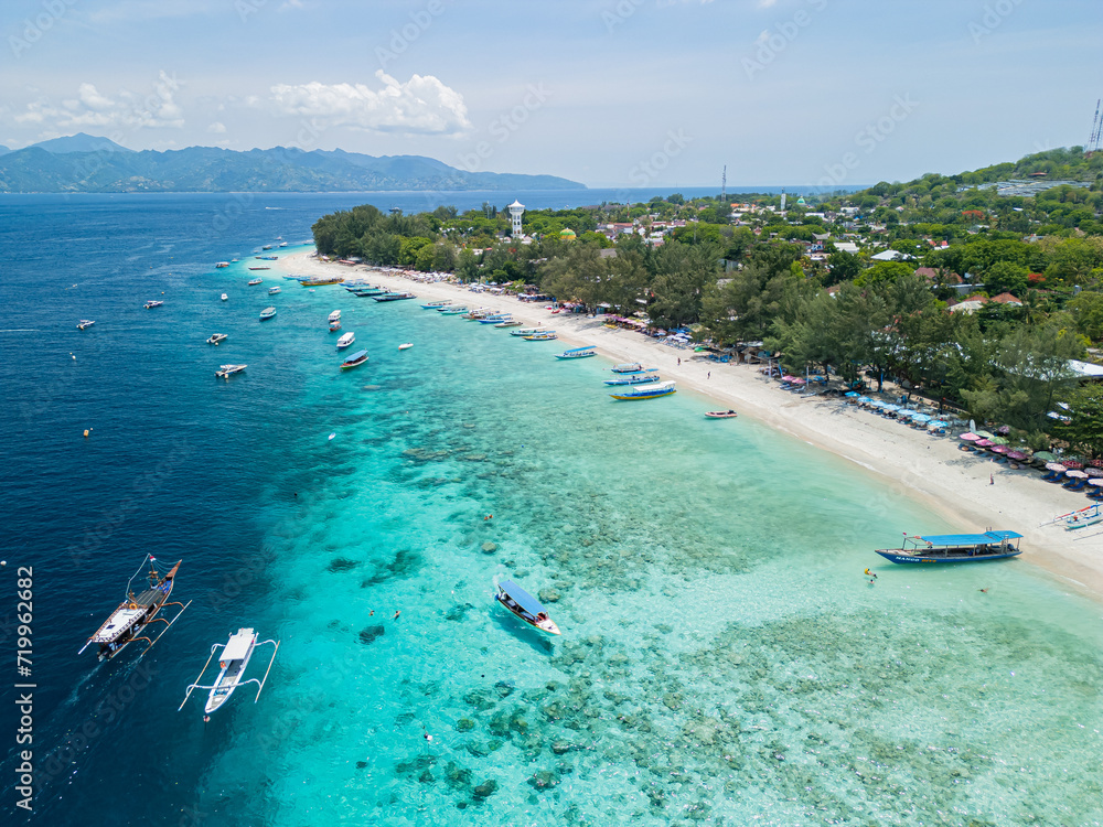Drone photo of Indonesian island, Gili Trawangan and its beautiful crystal clear waters ideal for snorkeling and sailing typical boats.