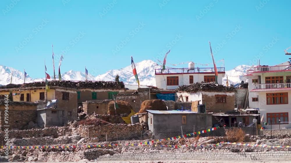 Nako Village in front of snow covered Himalayan mountain peaks as seen on the way to Spiti Valley in Himachal Pradesh, India. Beautiful mountain village in the Himalayas in winter season in India. Nako Village in front of snow covered Himalayan mountain peaks as seen on the way to Spiti Valley in Himachal Pradesh, India. Beautiful mountain village in the Himalayas in winter season in India.