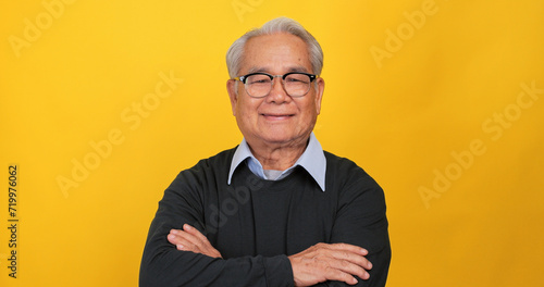 Close up, portrait of older man smiling and looking at the camera. Isolated on yellow background in the studio.
