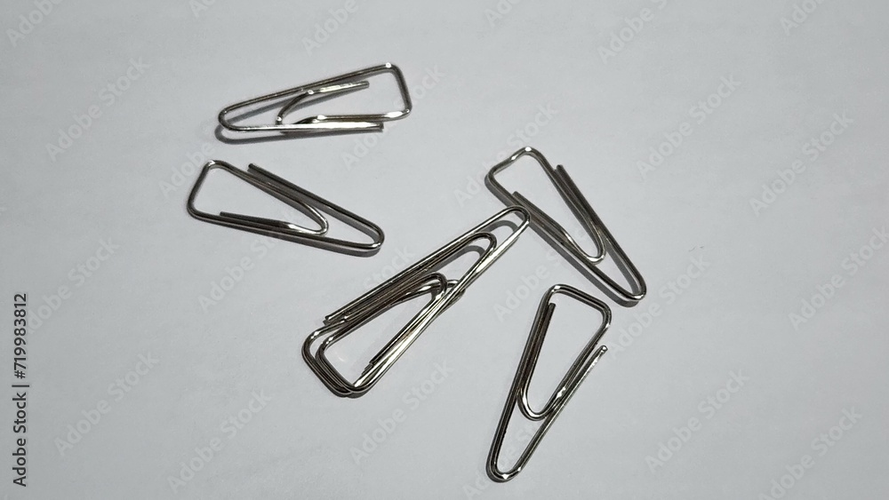 a group of four metal clips on a white surface a group of four metal clips on a white surface