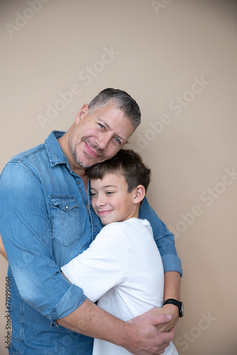 father and son are posing in front of brown background, love, family, teenager