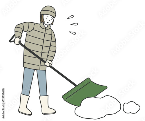 スコップを持って雪かきをする女性