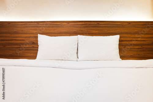 Fototapeta Naklejka Na Ścianę i Meble -  Clean Bedding sheets and pillow on natural wall room background. White bedding and pillow in hotel room.with pillows on empty bed