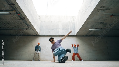 Group of stylish hipster perform dancing together in building. Happy break dancer enjoy moving to hip hop music with freestyle dance surrounded by street dancer team. Outdoor sport 2024. Sprightly. © Summit Art Creations
