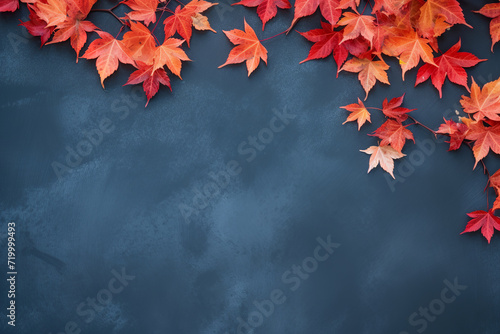 Autumn background with colorful red leaves on blue background with copy space