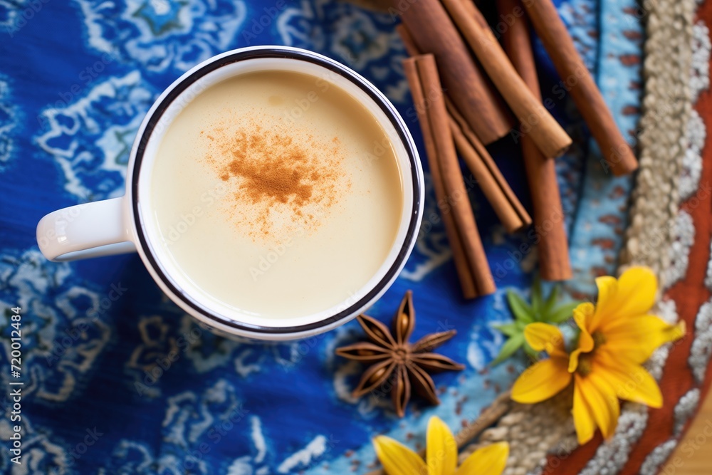 top view of a chai cup surrounded by cinnamon sticks and star anise top view of a chai cup surrounded by cinnamon sticks and star anise