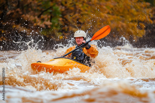 An adventurous man kayaking through the rough whitewater rapids in a river surrounded by autumn foliage.