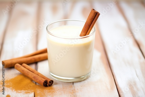closeup of eggnog in glass with cinnamon stick