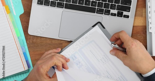 Business employee manually working with stacks of paper files to search and check unfinished archives top view
