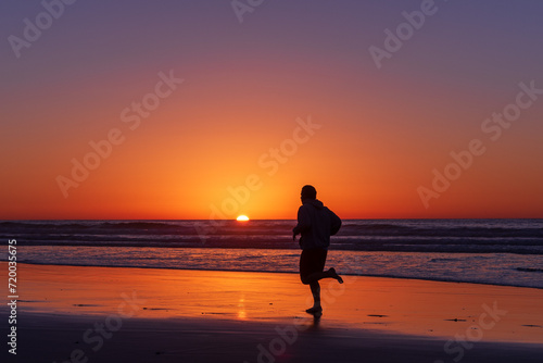 Sihouette of running man at Scripps Pier, La Jolla, California