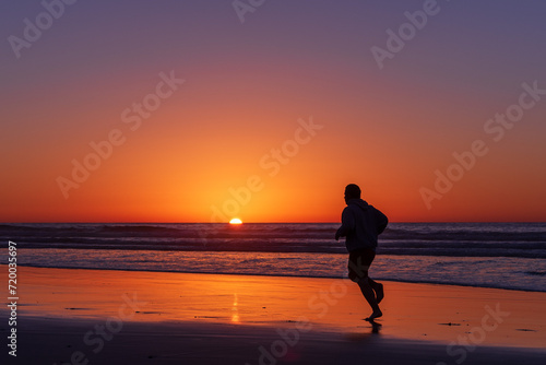 Fototapeta Naklejka Na Ścianę i Meble -  Sihouette of running man at Scripps Pier, La Jolla, California
