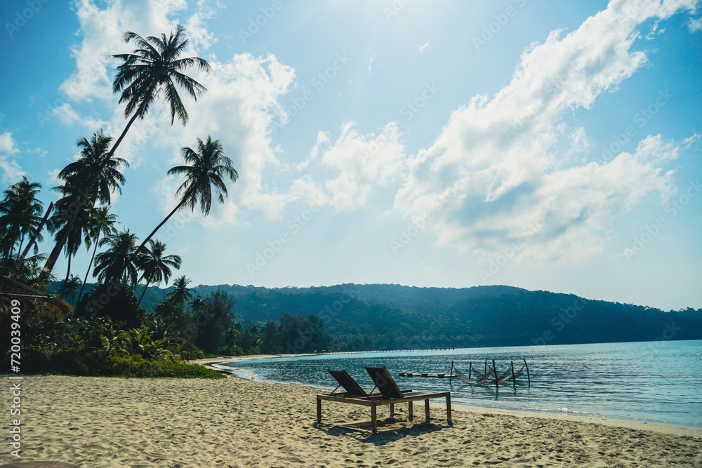 Two empty beach chairs and umbrella at a beach in Koh Kood, Thailand. Amazing scenery, relaxing beach, tropical landscape background. Luxury travel destination concept. Two empty beach chairs and umbrella at a beach in Koh Kood, Thailand. Amazing scenery, relaxing beach, tropical landscape background. Luxury travel destination concept.