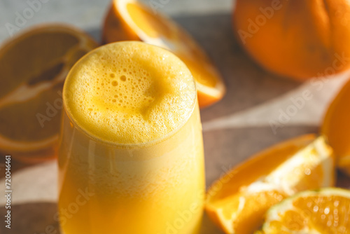 Close-up, glass of orange juice on a blurred background with oranges.