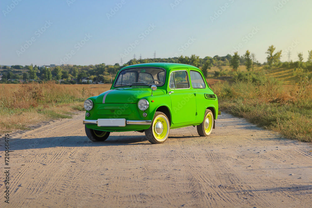 retro car near a private house on the road. Sunset. Bright car. Round headlights. High quality photo