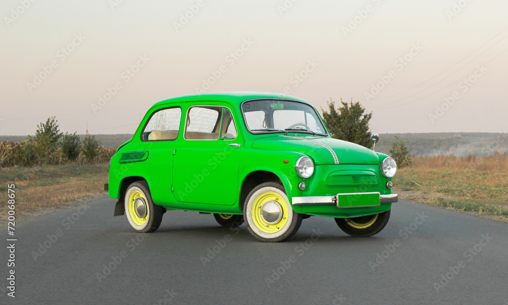 retro car near a private house on the road. Sunset. Bright car. Round headlights. High quality photo