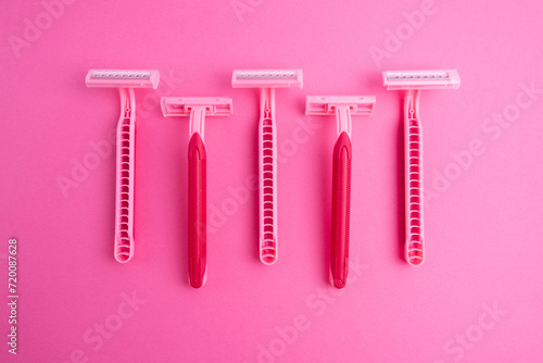 Pink women's razors isolated on yellow and pink background. Pink women's disposable razors. Skin and body care concept. Depilation. Place for text