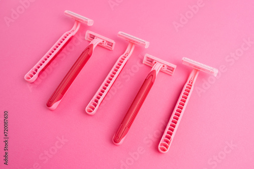 Pink women's razors isolated on yellow and pink background. Pink women's disposable razors. Skin and body care concept. Depilation. Place for text
