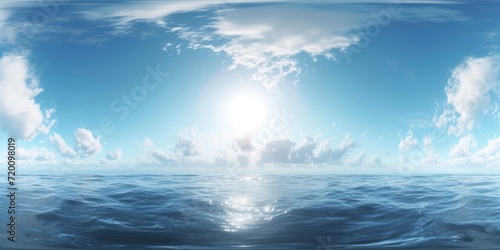 The sea with waves crashing on the shore. The waves are crashing against the sand  and the sun is shining through the clouds. The sky is blue and sunny  and there are white clouds in the sky