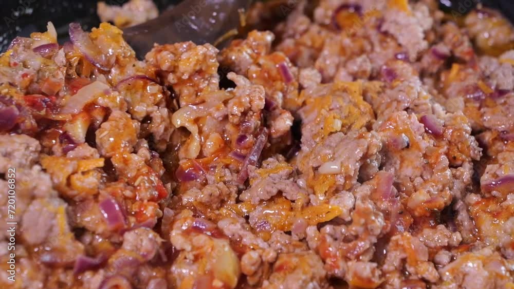 A dish of minced meat, tomato and vegetables is prepared in a pan. A dish of minced meat, tomato and vegetables is prepared in a pan.