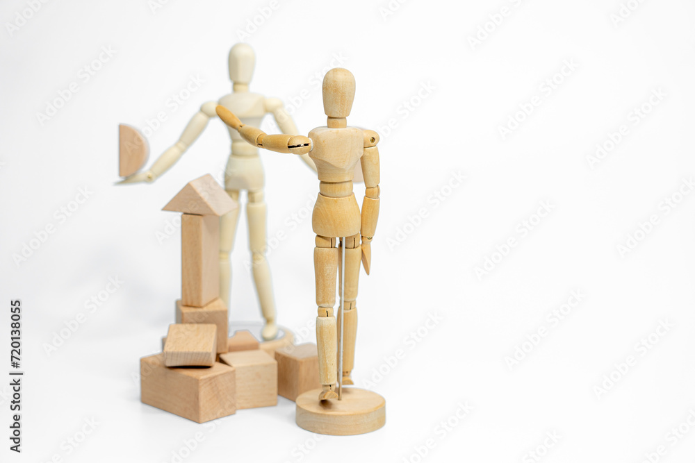 Wooden doll with wooden toy block isolated on white background. business or creative concept Wooden doll with wooden toy block isolated on white background. business or creative concept