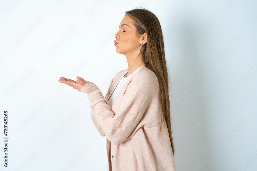 Profile side view, portrait of attractive beautiful girl wearing casual clothes sending air kiss Profile side view, portrait of attractive beautiful girl wearing casual clothes sending air kiss