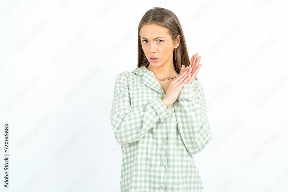 Surprised emotional Beautiful young woman wearing green plaid pyjama rubs palms and stares at camera with disbelief Surprised emotional Beautiful young woman wearing green plaid pyjama rubs palms and stares at camera with disbelief