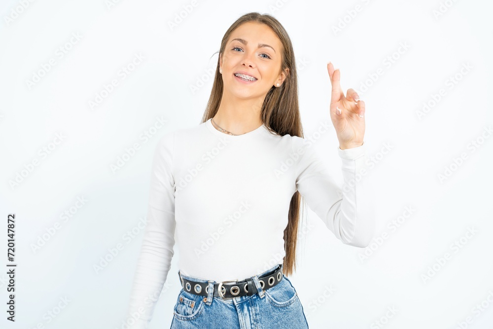 young beautiful girl wearing white T-shirt pointing up with fingers number ten in Chinese sign language Shi young beautiful girl wearing white T-shirt pointing up with fingers number ten in Chinese sign language Shi
