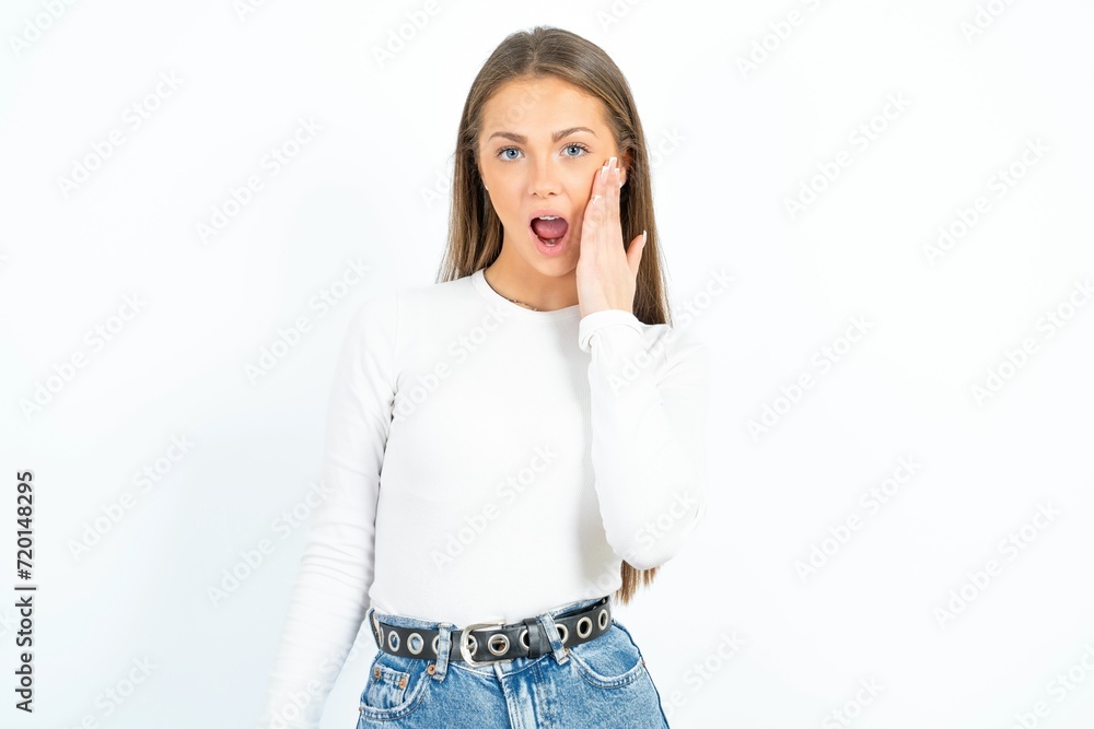 Shocked young beautiful girl wearing white T-shirt looks with great surprisment being very stunned, astonished with unexpected news, Facial expressions concept. Shocked young beautiful girl wearing white T-shirt looks with great surprisment being very stunned, astonished with unexpected news, Facial expressions concept.