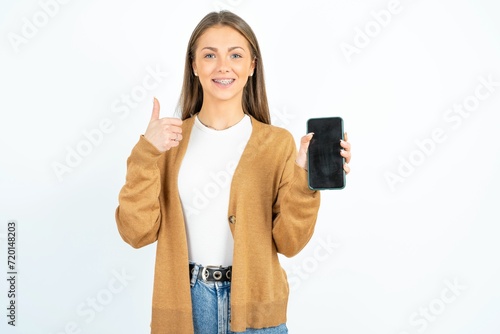 beautiful girl wearing casual clothes Show blank screen smartphone, thumb up recommend new app