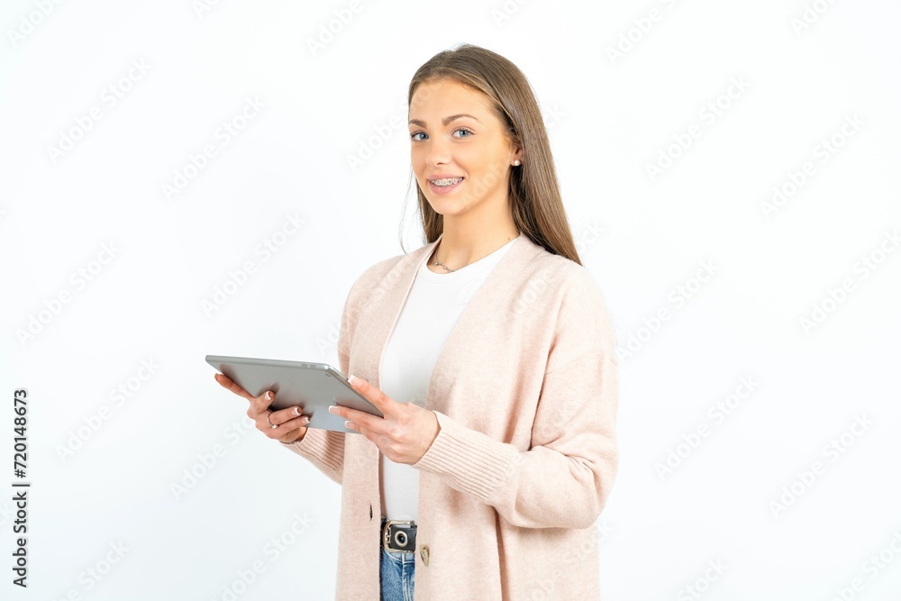 Photo of optimistic Young beautiful woman wearing pink cardigan hold tablet Photo of optimistic Young beautiful woman wearing pink cardigan hold tablet