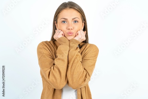 beautiful girl wearing casual clothes with surprised expression keeps hands under chin keeps lips folded makes funny grimace