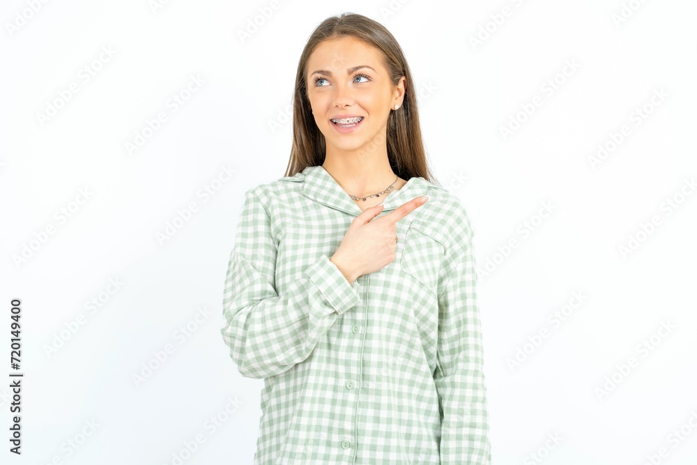 Beautiful young woman wearing green plaid pyjama glad cheery demonstrating copy space look novelty Beautiful young woman wearing green plaid pyjama glad cheery demonstrating copy space look novelty