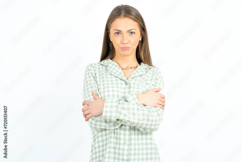Gloomy dissatisfied Young beautiful woman wearing green plaid pyjama looks with miserable expression at camera from under forehead, makes unhappy grimace Gloomy dissatisfied Young beautiful woman wearing green plaid pyjama looks with miserable expression at camera from under forehead, makes unhappy grimace