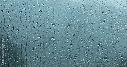Heavy storm rain droplets pattern on glass window.