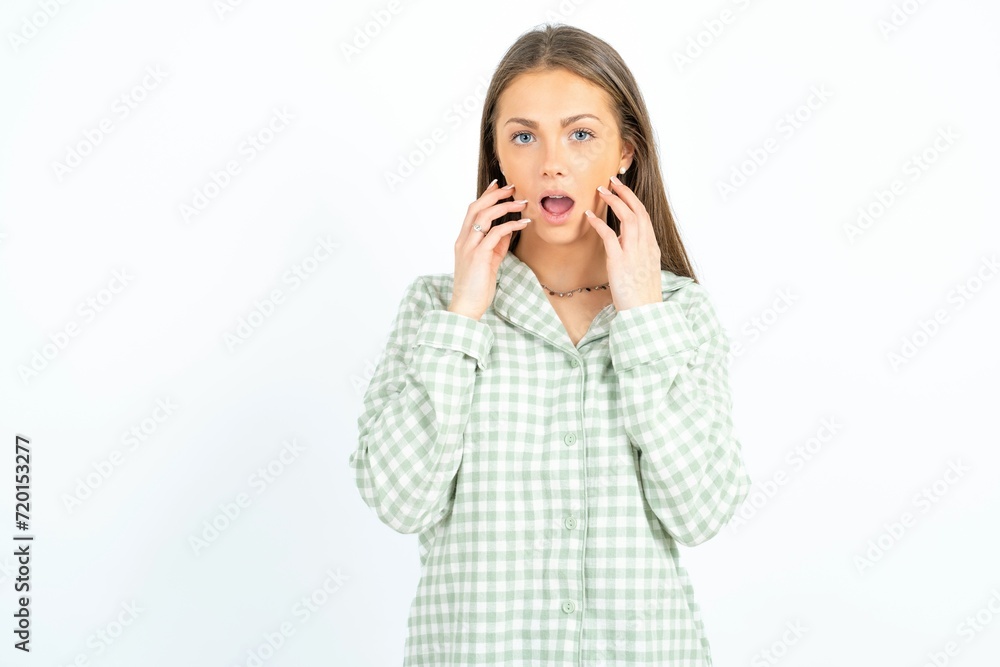 Speechless Young beautiful woman standing over white studio background keeps hands near opened mouth reacts to shocking news stares wondered at camera Speechless Young beautiful woman standing over white studio background keeps hands near opened mouth reacts to shocking news stares wondered at camera