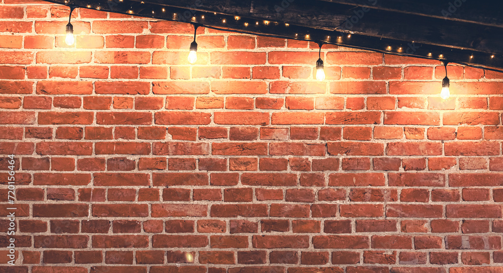 Lights garlands hanging from red brick wall at evening. Lights garlands hanging from red brick wall at evening.