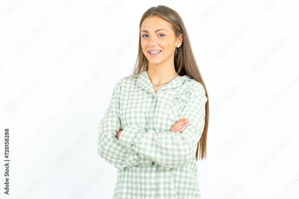 Portrait of young beautiful woman wearing green plaid pyjama, standing with folded arms and smiling Portrait of young beautiful woman wearing green plaid pyjama, standing with folded arms and smiling