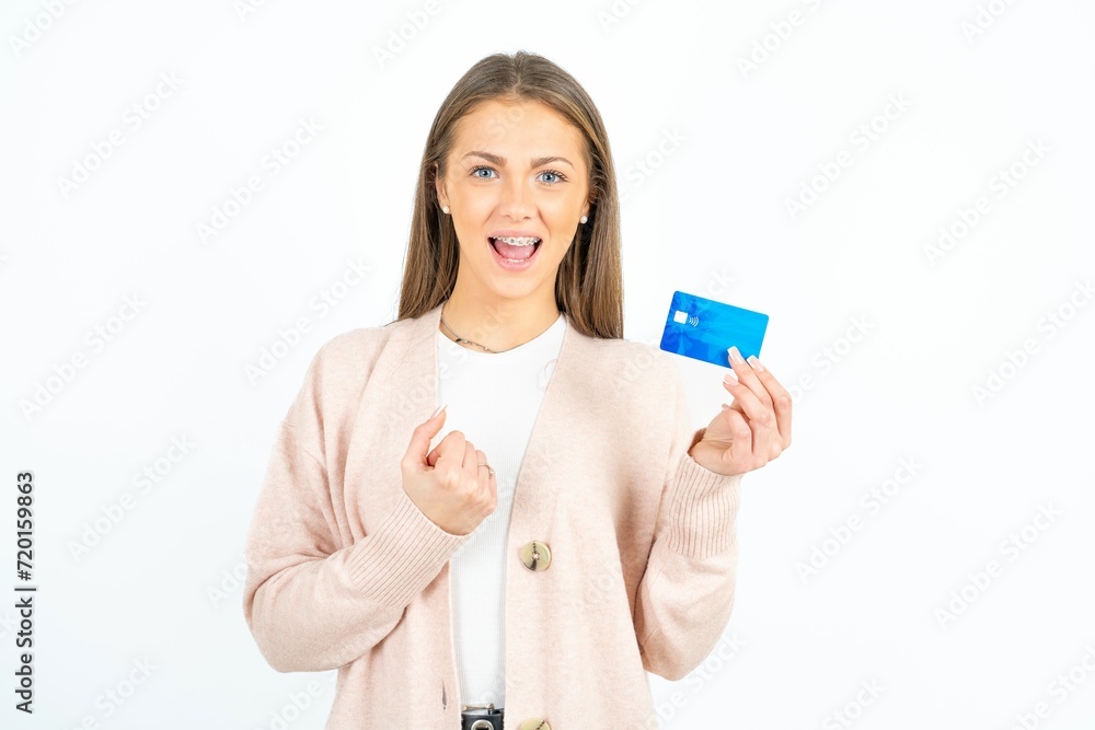 Excited happy positive cheerful smiling Young beautiful woman hold credit card raise fist in victory Excited happy positive cheerful smiling Young beautiful woman hold credit card raise fist in victory