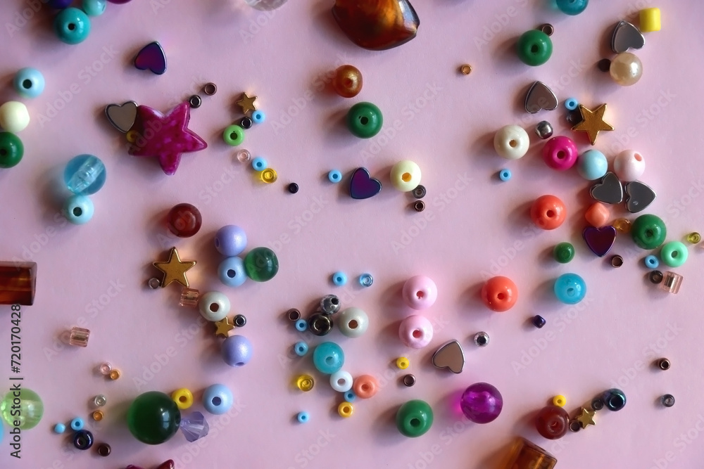 Various colorful beads on bright pink background. Top view. Various colorful beads on bright pink background. Top view.