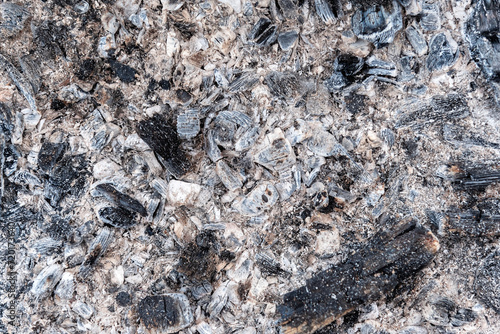 Coal  ash and cinders on a flat surface  all that is left of firewood. For use as an abstract background and texture.