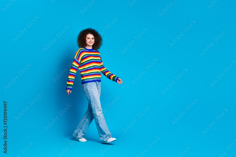 Full body photo of attractive young woman walking model wear trendy rainbow print clothes isolated on blue color background Full body photo of attractive young woman walking model wear trendy rainbow print clothes isolated on blue color background